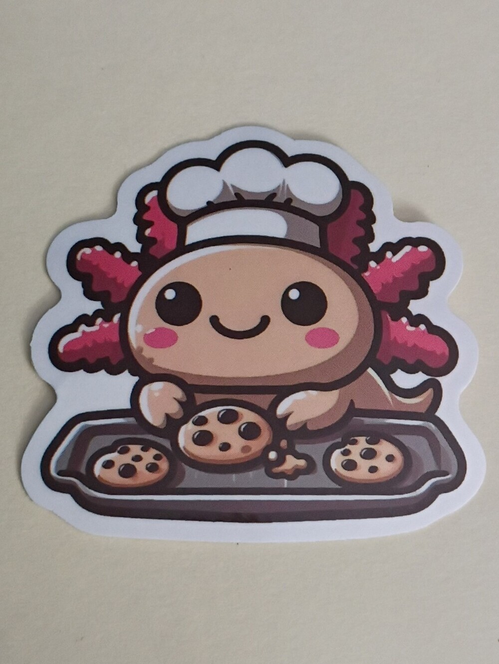 10/$10 Sticker - Axolotl Tan & Pink w/ Black Eyes & Chef's Hat Baking Cookies